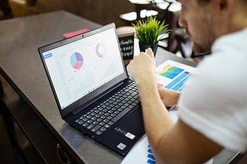 Obchodní analýzy, grafy a grafy, muž pracující, černý notebook, lavice, Nastavení kanceláře, Přezkum dat, Profesionální práce, obchodní grafy, laptop obrazovky, pracovní prostředí
