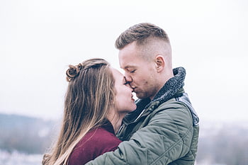 romantic couple, kissing outdoors, chilly day, warmth, affection, man holding woman, outdoor kiss, romantic moment, couple in love, winter romance, affectionate couple