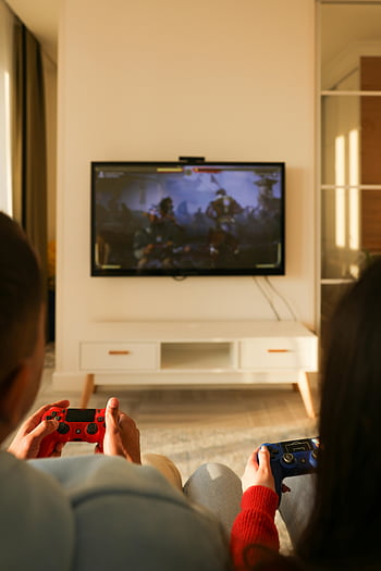 Pár hrající videohry, Play Station, útulný obývací pokoj, Relace videoher, televize, Herní ovladače, Červený ovladač, Modrý ovladač, zábava, domácí zábava, Pár her