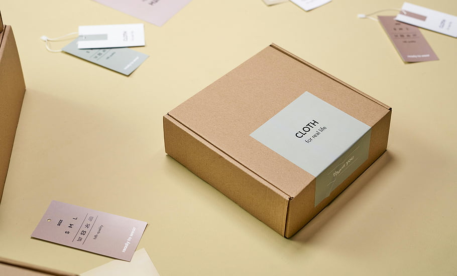 cardboard packaging, clothing labels, elegant packaging, product packaging, light surface, tags, minimalist design, retail packaging, eco-friendly packaging, product display, gift box
