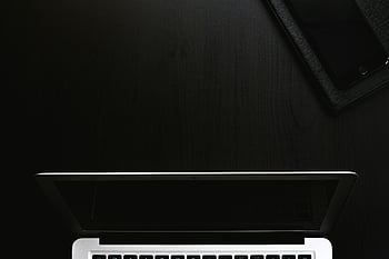stříbrný notebook, černý notebook, minimalistický pracovní prostor, elegantní design, Tmavý povrch, chytrý telefon, nastavení tech, moderní technologie, kancelářský stůl, Nástroje produktivity