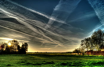 countryside landscape, dramatic clouds, sunset, vibrant colors, natural beauty, green grass, blue sky, rural scene, scenic view, outdoor scenery, peaceful environment