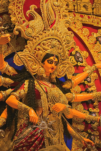 Durga idol, Kolkata festival, Durga Puja, cultural artistry, intricate idol, golden adornment, Indian festival, traditional art, goddess Durga, festive celebration, cultural heritage