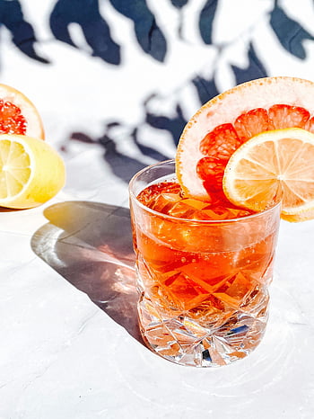 Zitruscocktail, Grapefruitscheiben, Zitronenscheiben, Kristallglas, Sommergetränk, heller Saft, Erfrischendes Getränk, Zitrusfrüchte, Cocktail Glas, Sommererfrischung, Orangengetränk