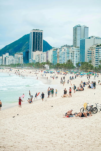 Copacabana Beach, Rio de Janeiro, Brazil, crowded beach, modern skyscrapers, mountain backdrop, summer vacation, beach activities, tropical destination, city skyline, beachgoers