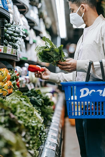 young man, mask, choosing veggies, modern supermarket, healthy shopping, fresh vegetables, supermarket aisle, healthy lifestyle, man wearing mask, grocery shopping, fresh produce