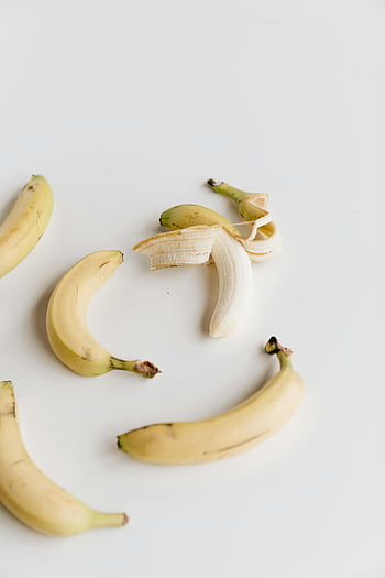 dojrzałe banany, biała powierzchnia, elegancko zaaranżowany, świeżość, prostota, obrany banan, skórka banana, żółte banany, białe tło, fotografia owocowa, Minimalistyczna fotografia żywności
