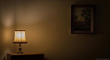 table lamp, nightstand, painting, wall, warmly lit room, vintage lamp, framed painting, interior decor, cozy atmosphere, home decor, ambient lighting