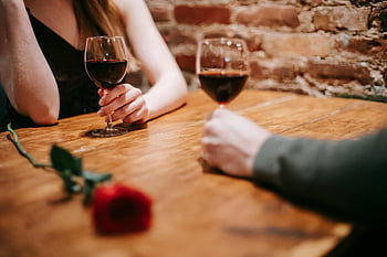 pár k datu, vinné skleničky, Útulná restaurace, romantická růže, intimní scéna, užívat si víno, Nepoznatelný pár, Romantická atmosféra, jídelní stůl, červené víno, cihlová zeď
