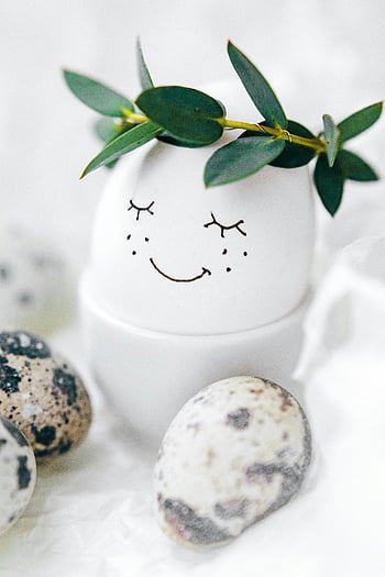 Easter egg, painted face, leafy crown, quail eggs, white background, decorative egg, simple design, spring decoration, festive egg, Easter decoration, egg art