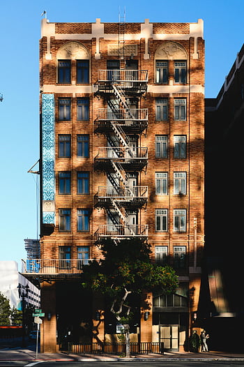 bâtiment résidentiel de la ville, fond bleu, construction urbaine, escalier de secours, Soleil chaud, architecture classique, paysage urbain, bâtiment en brique, les fenêtres, balcons, arbre