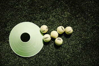 golf balls, golf disc, training cone, vibrant green grass, practice, white golf balls, golf equipment, outdoor sports, golf training, golf practice, golf accessories