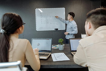 pracovní schůzka, muž prezentace, Modrá košile s dlouhým rukávem, Projektová strategie, moderní kancelář, Diskuse týmu, Prezentace tabule, notebooky, Kancelářské prostředí, Profesionální nastavení, Kolaborativní práce