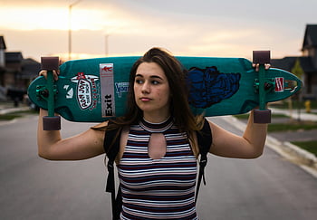 dospívající dívka, Longboard Skateboard, příměstská ulice, západ slunce, Moderní styl brusle, ramenní nošení, Výřez kol, skateboarding, venkovní aktivita, neformální móda, pouliční scény