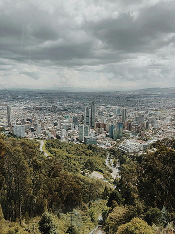 flygperspektiv, Bogota skyline, frodig grönska, dramatiska moln, stadsbild, stadslandskap, högvinkelskott, storstadsområde, naturliga omgivningar, moderna byggnader, mulet väder