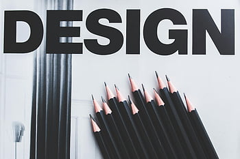 black pencils, design word, large typography, creative arrangement, design concept, black and white, artistic composition, graphic design, visual art, stationery items, modern design