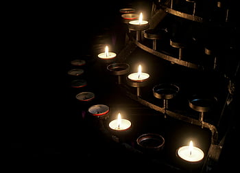 votive candles, candle holder, dimly lit scene, burning candles, dark surroundings, candlelight, five candles, candle illumination, votive candle holder, candle ambiance, candlelight scene