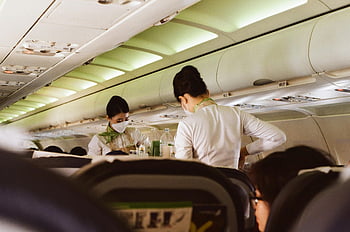 flight attendants, face mask, airplane aisle, white uniforms, serving passengers, Vietnam airplane, onboard service, cabin crew, safety measures, air travel, flight service