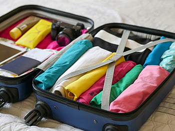 blue luggage, folded clothes, open suitcase, colorful clothes, travel essentials, neatly packed, travel packing, suitcase contents, clothing organization, travel preparation, luggage contents