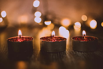 tea candles, macro shot, red glittery candles, warm ambiance, cozy atmosphere, celebrations, candlelight, festive mood, close-up photography, burning candles, glittery wax