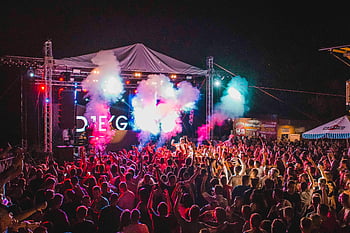 outdoor music festival, vibrant lights, crowd energy, dynamic performance, concert, lively atmosphere, festival crowd, stage lights, night event, music event, festival scene