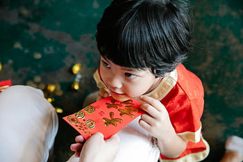 Hongbao, Rotes Paket, Neujahr, Festliche Feier, Kind, traditioneller Umschlag, Innenparty, Mutter gibt, Sohn empfängt, glücklicher Moment, kulturelle Tradition