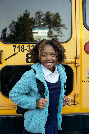 black schoolgirl, backpack, school bus, cheerful girl, smiling, yellow bus, school uniform, outdoor, education, student, happiness