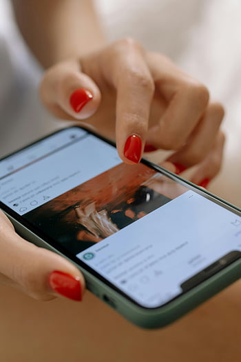 woman scrolling, Instagram feed, red nails, smartphone, social media app, woman using phone, social media browsing, mobile app, digital engagement, online interaction, social networking
