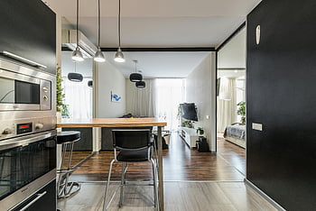 moderne keuken, ingebouwde apparaten, ruim appartement, open lay -out, stijlvol appartement, eethoek, woongedeelte, eigentijds ontwerp, houten vloer, zwart meubilair, hanglampen