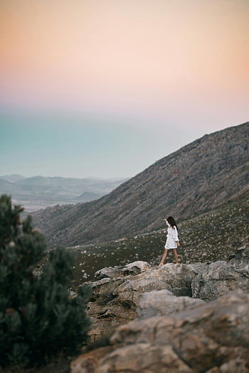 žena chodící po skalách, klidný západ slunce, skalnatý terén, pozadí hory, bílé šaty, fotografování přírody, venkovní dobrodružství, Zůstatek, krajinářské fotografie, cestovní fotografie, hledač dobrodružství