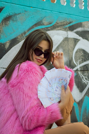 pink fur coat, sunglasses, holding cash, confident woman, fashion style, street fashion, urban style, graffiti background, trendy outfit, luxury fashion, confident pose