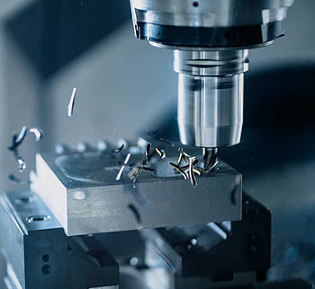 CNC frézka, kovový nástroj, Přesná výroba, detailní fotografie, kovové obrábění, průmyslové vybavení, proces zpracování kovů, obráběcí stroj, kovovýroba, přesné řezání, kovové hobliny