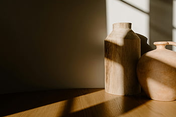 brown wooden vase, clay pot, minimalist decor, soft light, shadows, wooden surface, clay and wood vases, natural light, interior design, home decor, rustic style