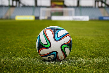 Adidas soccer ball, green field, sports enthusiasts, vibrant colors, open field, soccer ball, Adidas brand, grass field, sports equipment, outdoor sports, football