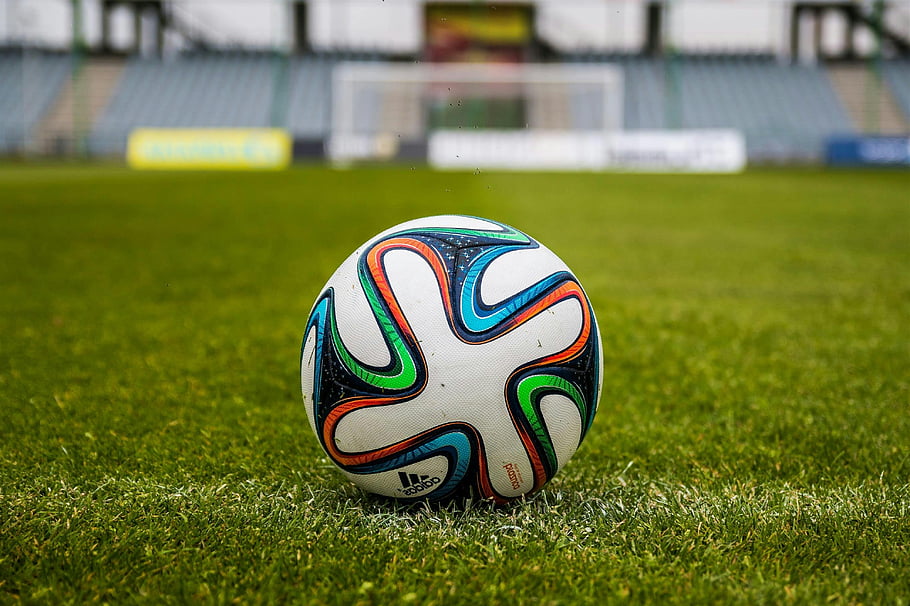 fotbalový míč adidas, zelené pole, sportovní nadšenci, zářivé barvy, otevřené pole, fotbalový míč, značky adidas, travnaté hřiště, sportovní vybavení, venkovní sporty, Fotbal
