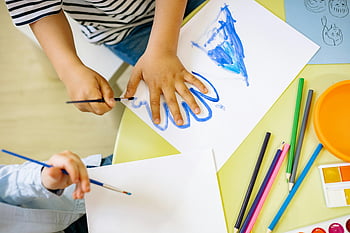 children painting, watercolors, colored pencils, hand tracing, creativity, learning, fun environment, art supplies, educational activities, kids drawing, artistic skills