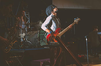 live band performance, man playing guitar, stage musicians, dynamic performance, instruments on stage, guitar player, live music, band on stage, musical performance, stage performance, guitar performance