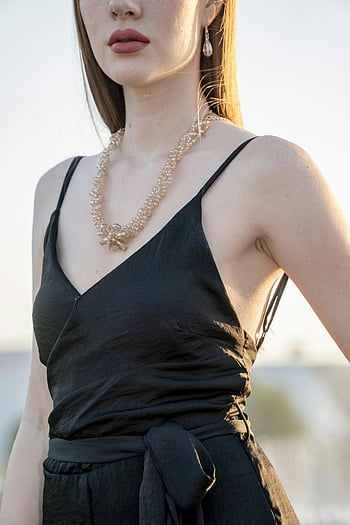 Černé šaty pro špagety, Zlatý náhrdelník, elegantní šperky, stylová žena, venkovní nastavení, černé šaty, elegantní žena, Venkovní móda, Stylový outfit, elegantní příslušenství