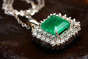 silver-colored pendant, green gemstone, emerald pendant necklace, white gold, shimmering diamonds, luxury jewelry, elegant jewelry, emerald jewelry, diamond necklace, luxury pendant, elegant pendant