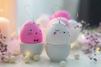Easter bunny eggs, pink and white, ceramic cups, soft pastel colors, seasonal decoration, charming Easter eggs, bunny faces, Easter decoration, pastel Easter eggs, ceramic egg cups, Easter bunny theme