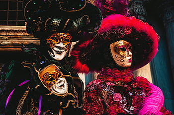 Venetian masks, traditional carnival, Venice Italy, red and black floral headdress, vibrant masks, carnival celebration, Venetian costumes, festive attire, cultural event, ornate masks, carnival masks