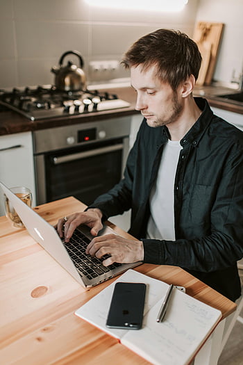 man met laptop, moderne keuken, afstandswerk, jonge man, laptop, keukenomgeving, werk levensstijl, werken op afstand, thuiskantoor, werken vanuit huis, digitale nomade