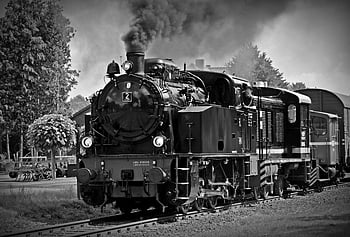 black and white photo, classic steam locomotive, emitting smoke, high angle view, railroad tracks, historical train travel, nostalgia, vintage train, black and white, steam engine, train station