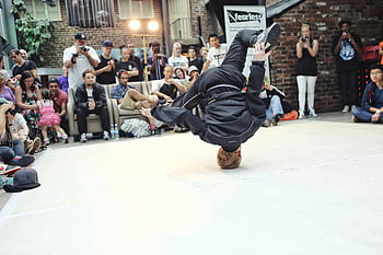 breakdancer, head spin, street performance, acrobatic move, crowd attention, vibrant dance, urban dance, street dance, breakdance move, public performance, dance event