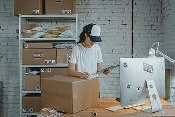 donna che scrive, scatola di cartone, appunti, logistica di spedizione, piccola impresa, Gestione dell'inventario, Eseguire gli ordini, magazzino, confezione, scrivania, computer