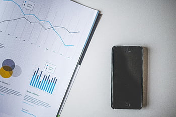 Black iPhone 5, beside paper, financial charts, business data, smartphone, office desk, graph analysis, mobile device, work environment, tech tools, document review