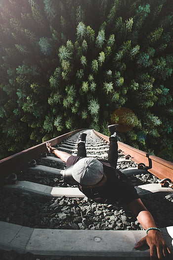 man, gray railing, train tracks, forest view, daring pose, railway, outdoor adventure, nature photography, man on tracks, forest landscape, railway bridge