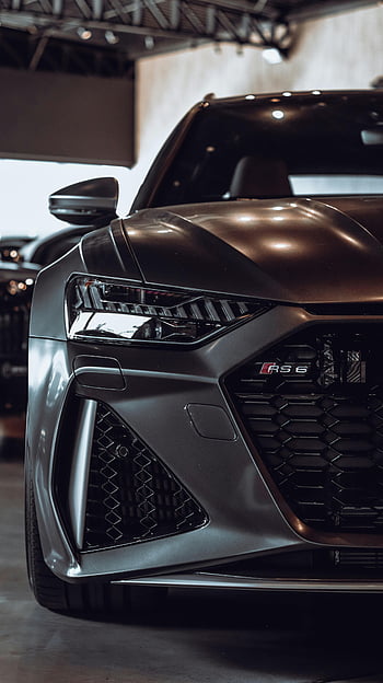 Audi RS6, luxury car, brown car, showroom setting, close-up shot, shiny headlight, high-end vehicle, performance car, automotive design, car enthusiasts, premium automobile