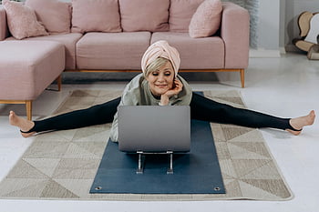 starší žena, Vnitřní jóga, strečink, laptop, domácí cvičení, zdravý životní styl, relaxace, podložka na jógu, neformální oblečení, obývací pokoj, utěšit