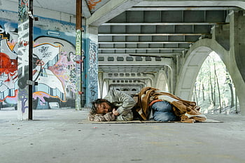 homeless man, sleeping, cardboard, graffiti-laden bridge, under bridge, homeless, poverty, urban poverty, street life, social issues, homeless shelter